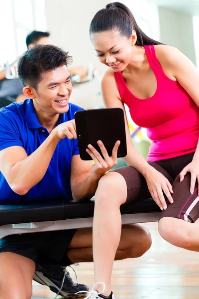 Entraîneur personnel avec femme dans la salle de fitness — Photo