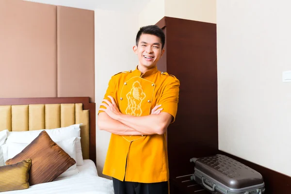 Portero chino trayendo maleta a la habitación del hotel —  Fotos de Stock