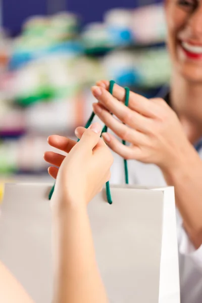 Wanita apoteker di apotek dengan pelanggan — Stok Foto