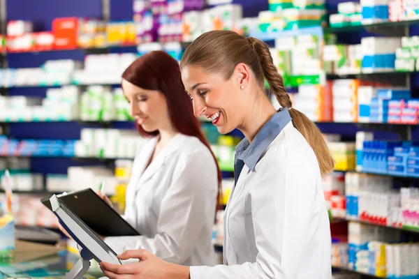 Farmacêutico com assistente na farmácia — Fotografia de Stock