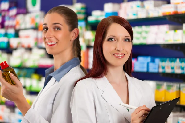 Farmacêutico com assistente na farmácia — Fotografia de Stock