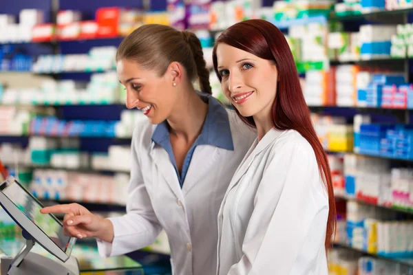 Farmacêutico com assistente na farmácia — Fotografia de Stock