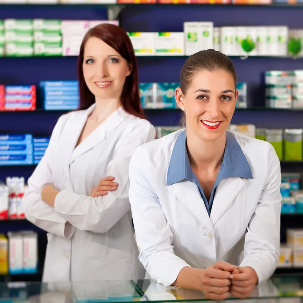 Farmacêutico com assistente na farmácia — Fotografia de Stock