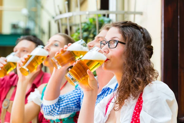 Люди, пьющие пиво в баварском ресторане или пабе — стоковое фото