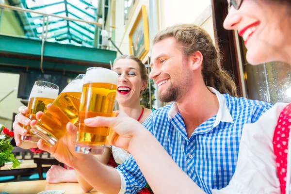 Amigos bebiendo cerveza en el restaurante o pub bávaro — Foto de Stock