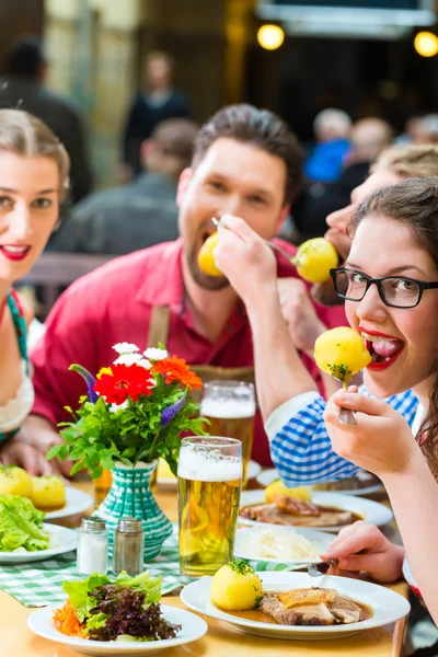 People in bavarian Tracht eating in restaurant or pub — Stock Photo, Image