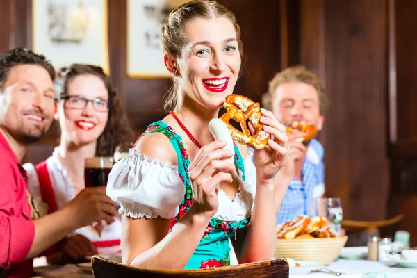 Personas en bavarian Tracht comer en restaurante o pub —  Fotos de Stock