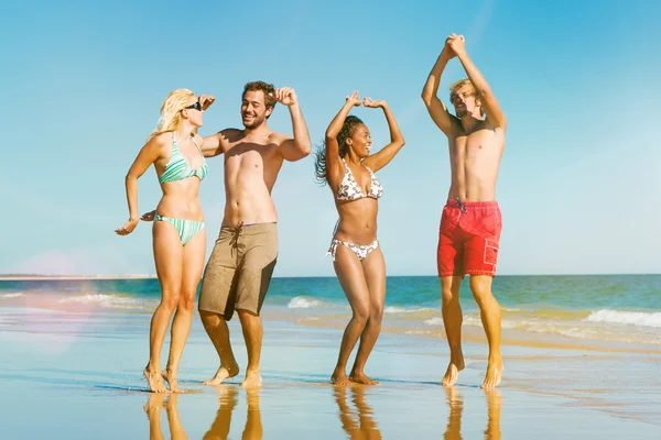 Vrienden springen op oceaan strand in vakantie — Stockfoto