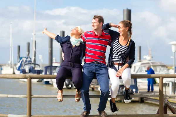 Vrienden zitten op marina pier — Stockfoto