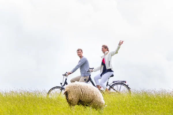 Couple having sea coast bicycle tour at levee — Stock Photo, Image