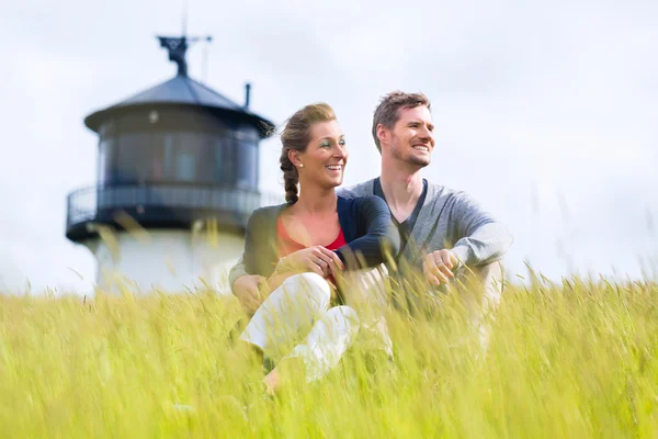 Pareja disfrutando de unas vacaciones frente al faro —  Fotos de Stock