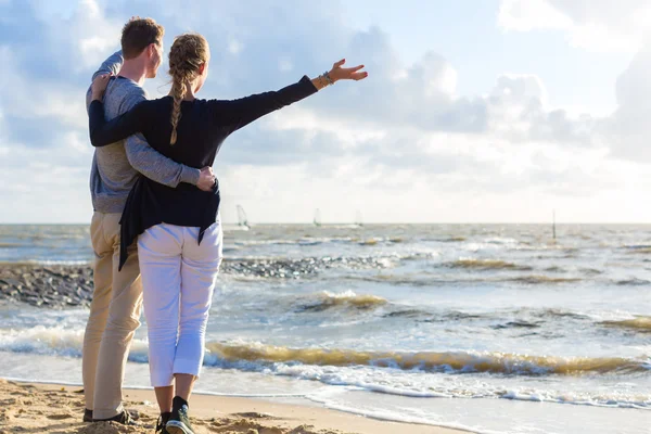 Para w romantyczny zachód słońca na plaży oceanu — Zdjęcie stockowe