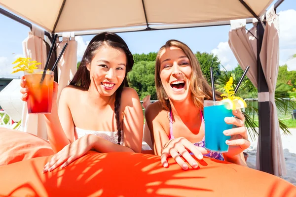 Girls in sound loungers at beach bar with drinks — Stok fotoğraf