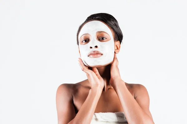 Mulher africana bonita no estúdio com máscara facial — Fotografia de Stock