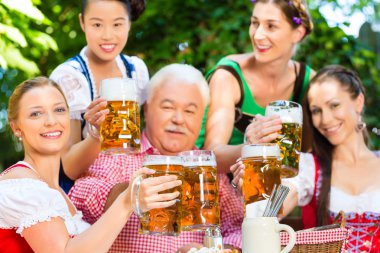 In Beer garden - friends drinking beer in bavaria clipart