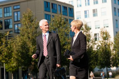 İş adamları dışarıda konuşuyor.