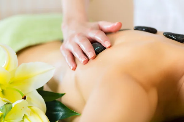 Mulher tendo bem-estar massagem de pedra quente — Fotografia de Stock