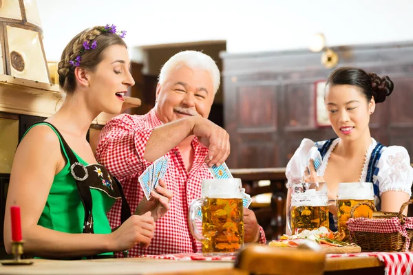 Znajomych do picia piwa w bawarskiej pub karty do gry — Zdjęcie stockowe
