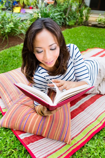 Asijská žena doma v zahradní čtení knihy — Stock fotografie
