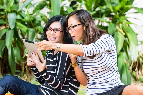 İki Asyalı kız arkadaşım tablet bilgisayar ile — Stok fotoğraf
