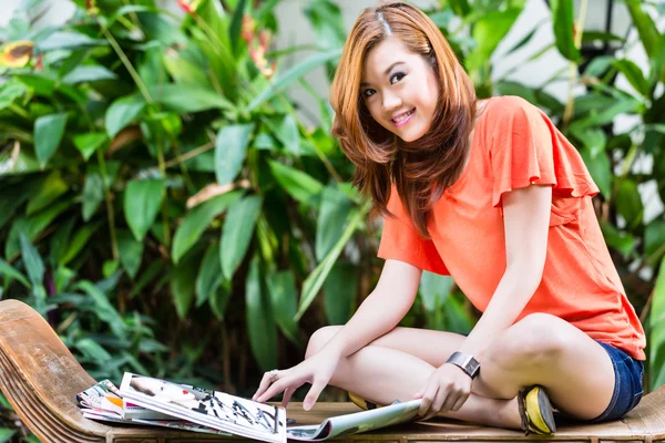 Wanita Asia muda membaca majalah fashion — Stok Foto