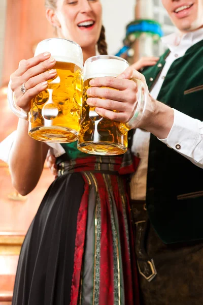 Man en vrouw met bierglas in brouwerij — Stockfoto