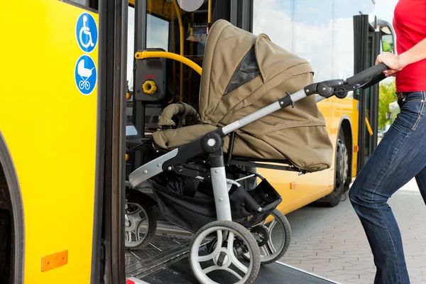 Vrouw met de kinderwagen krijgen in een bus — Stockfoto
