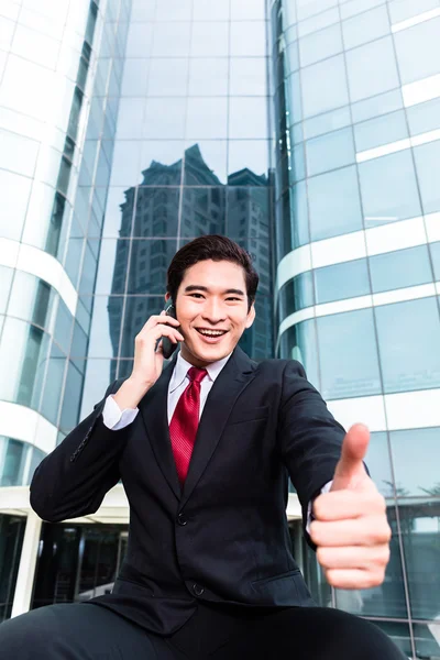 Asiático homem de negócios falando fora para o telefone móvel — Fotografia de Stock