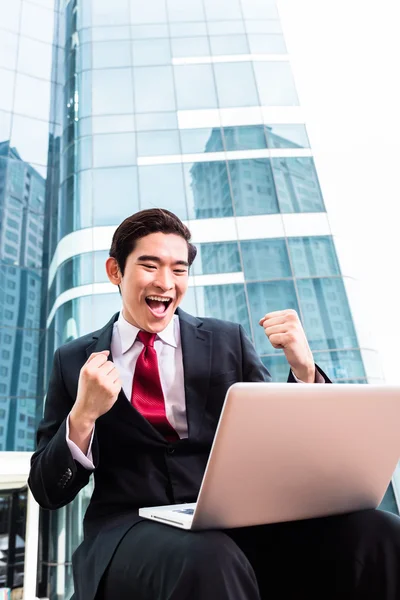 Asian business man working outside on computer — Stock Photo, Image