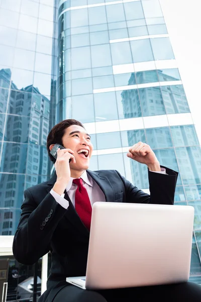 Asian business man working outside on computer — Stock Photo, Image