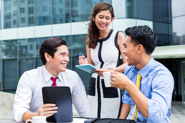 Asian businesspeople working outside with coffee — Stock Photo, Image