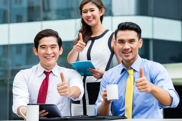 Empresarios asiáticos trabajando fuera con café — Foto de Stock