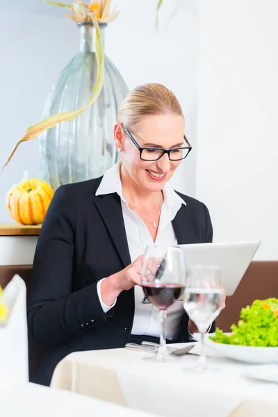 Mujer de negocios con tablet en restaurante — Foto de Stock