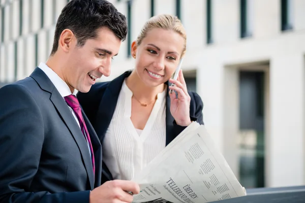 Üzleti férfi és nő a papír és a telefon — Stock Fotó