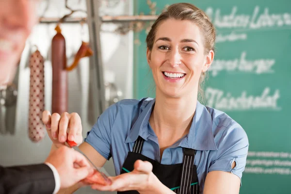 Hübscher Metzger verkauft Fleisch an Kunden — Stockfoto