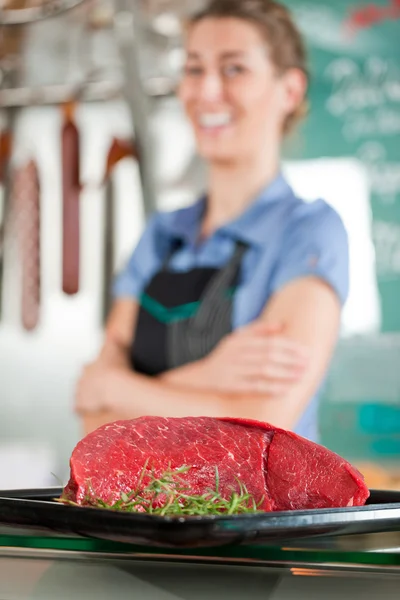 Hovězí maso s řezníkem v pozadí — Stock fotografie