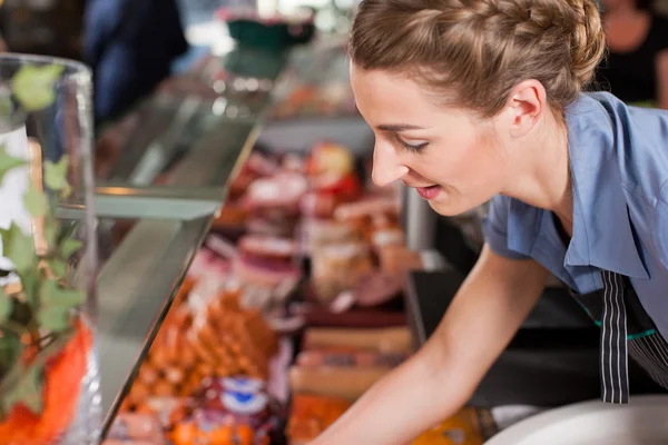 Slager verkoop van levensmiddelen op slagerij — Stockfoto