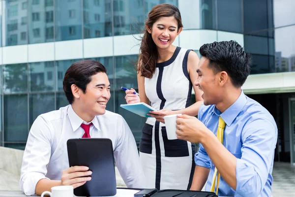 Asian businesspeople working outside with coffee Stock Picture