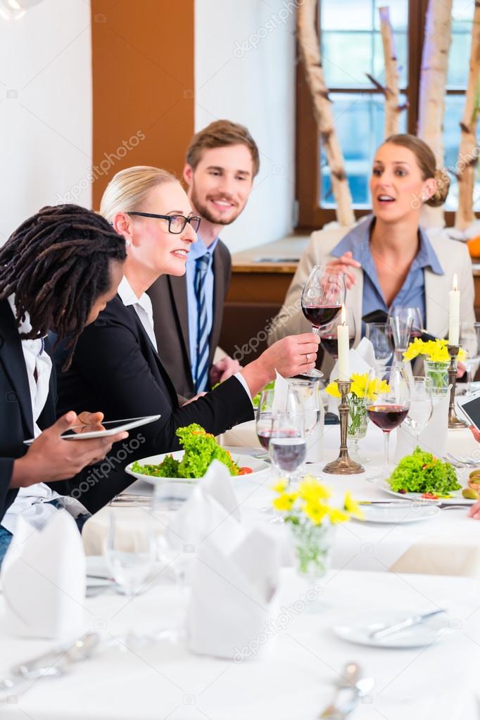 Team at business lunch meeting in restaurant — Stock Photo © Kzenon
