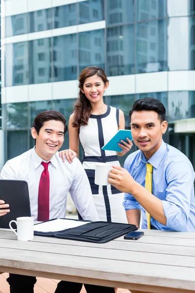 Empresarios asiáticos trabajando fuera con café —  Fotos de Stock