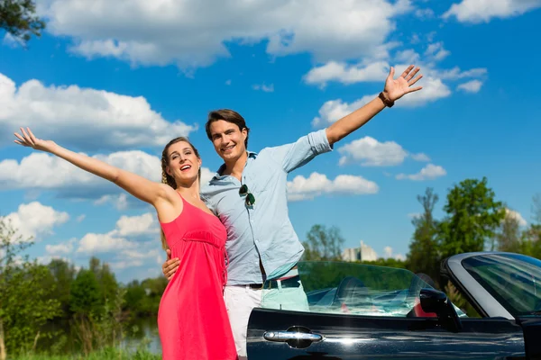 Ungt par med cabriolet på sommaren på dagstur — Stockfoto