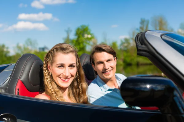 Young couple with cabriolet in summer on day trip — Stock Photo, Image