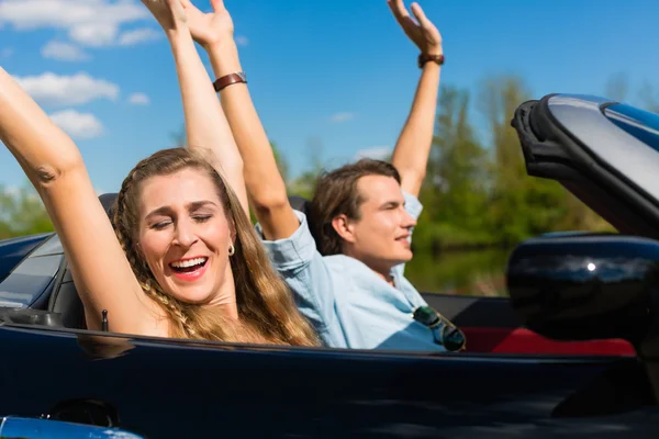 Mladý pár s cabriolet v létě na výlet — Stock fotografie