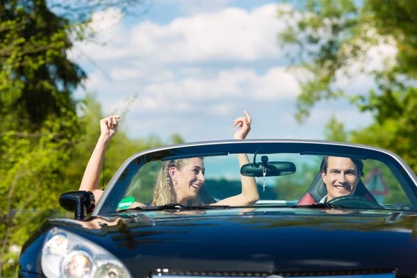 Mladý pár s cabriolet v létě na výlet — Stock fotografie