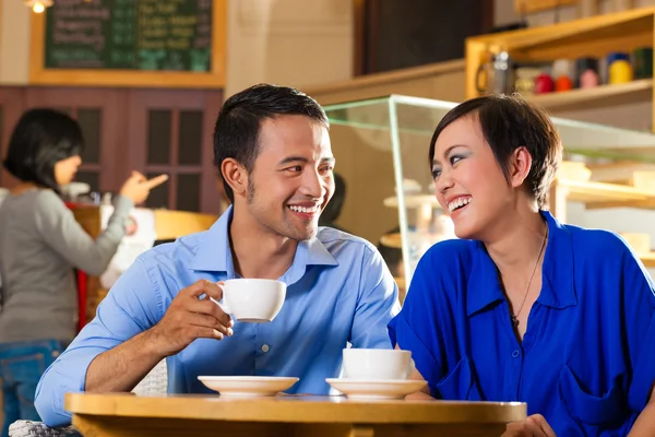 Азиатка и мужчина в кофейне — стоковое фото