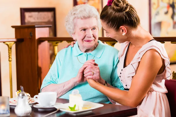 Senior vrouw en kleindochter op koffie in café — Stockfoto