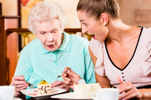 Старшая женщина и внучка за кофе в кафе — стоковое фото