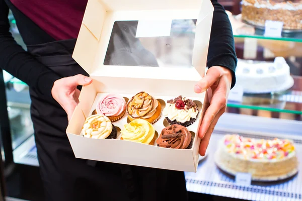 Woman presenting takeaway boxes of confectionery — Stock Photo, Image