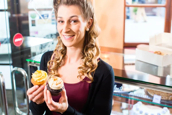 Wanita mempersembahkan cupcakes dari manisan — Stok Foto