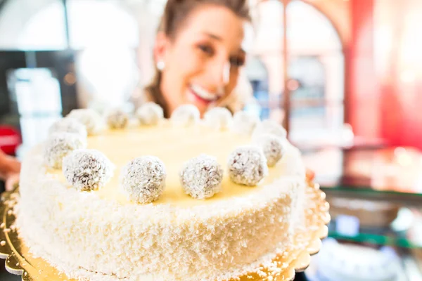 Θηλυκό baker, παρουσιάζοντας την τούρτα στο ζαχαροπλαστείο — Φωτογραφία Αρχείου